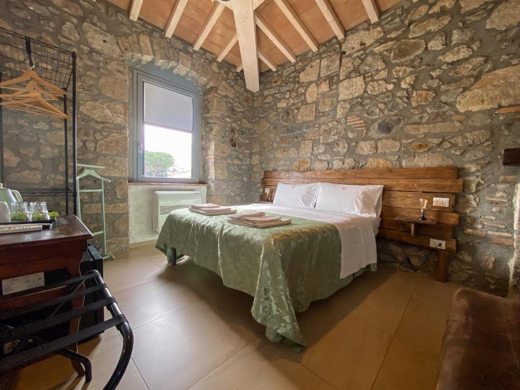 博尔塞纳Casale 1541的卧室配有一张石墙床