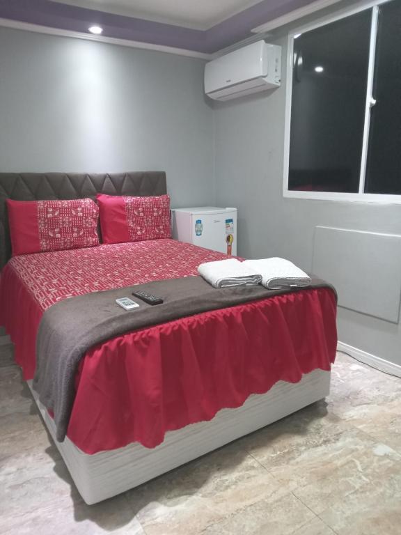 萨尔瓦多São Salvador Guest House的一间卧室配有一张带红色枕头的床和一扇窗户
