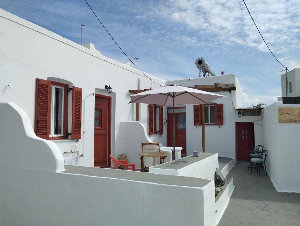 Péran TriovasálosVenduri House的白色的房子,配有雨伞和桌子