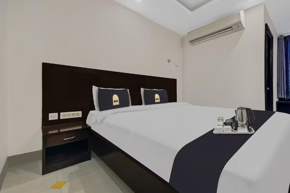 斋浦尔Tipsyy Inn & Suites Jaipur的一间卧室配有一张大床,上面有电话