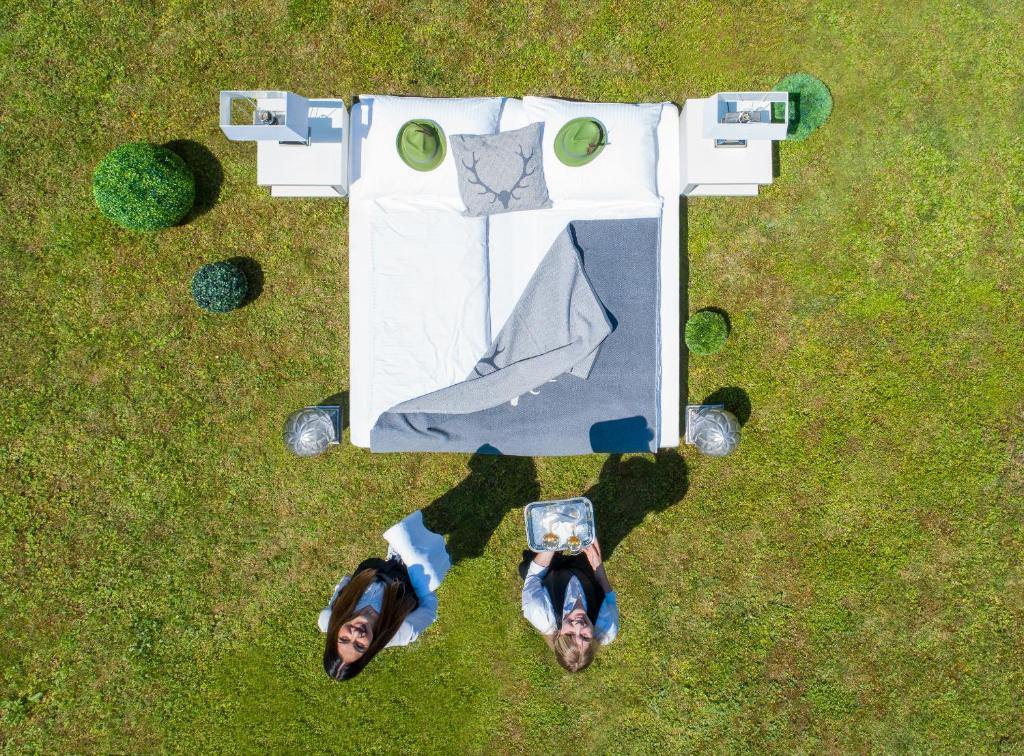 瑟绍胡博图斯酒店的两个人站在草地上的桌子旁边