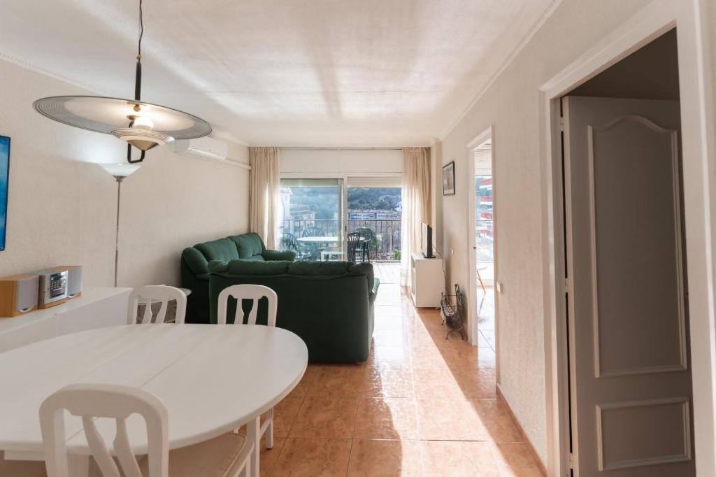 滨海托萨Apartamento Pau Picasso con terraza Tossa de Mar的客厅配有白色桌子和绿色沙发