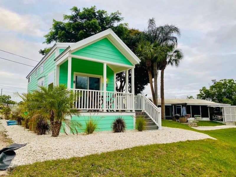 萨拉索塔Pinecraft Tiny Home 'Green Parrot '的海滩上带门廊的绿色房屋