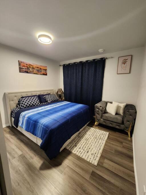 艾尔德里Cozy one bedroom in Airdrie的一间卧室配有蓝色的床和椅子