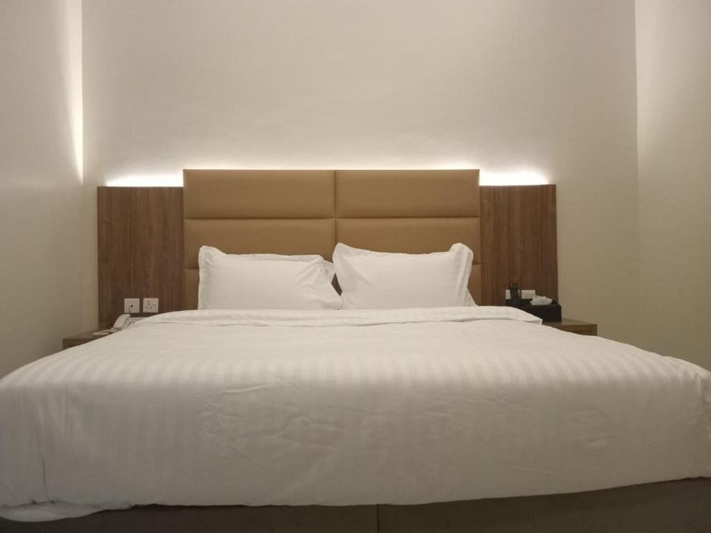 利雅德فندق دره الراشد للشقق المخدومه的卧室配有一张带白色床单和枕头的大床。