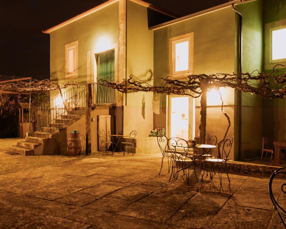 维拉·普拉亚·德·安科拉Quinta da Quinhas的一座晚上配有椅子和桌子的建筑
