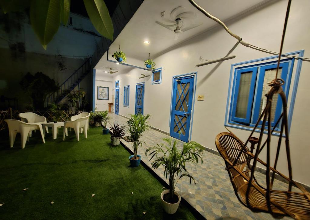 勒克瑙Sunlit stays-Forest view的一个带椅子的庭院和一扇蓝色门的房间
