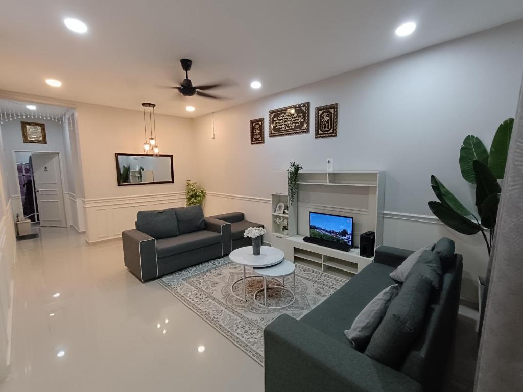 甘榜甘马挽JRC Homestay Kerteh的客厅配有两张沙发和一台电视机