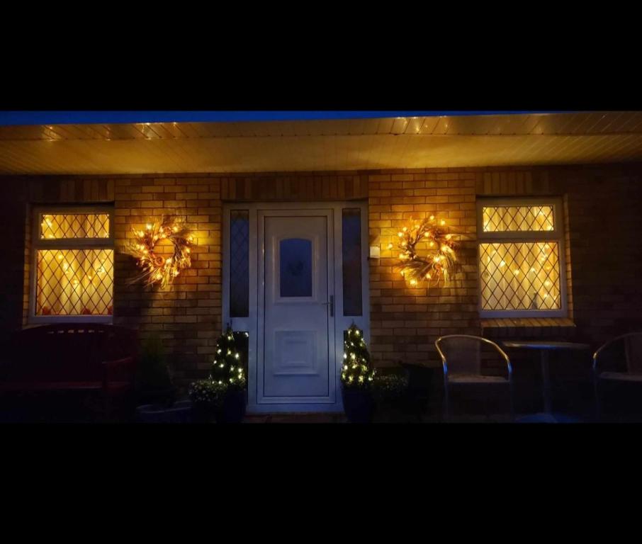 利默里克Stay With Jack的一座配有圣诞灯和白色门的房子