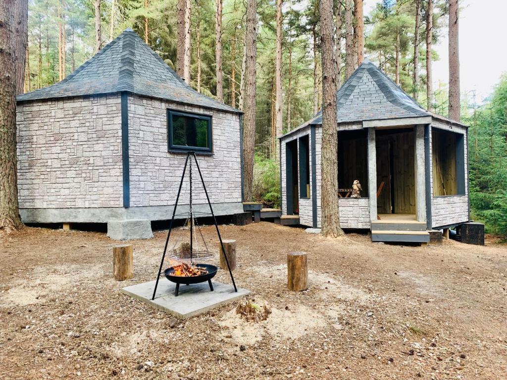 MunlochyHagrids Hut - Off grid Cabin - no electricity or running water的树林中的小屋,前面有火