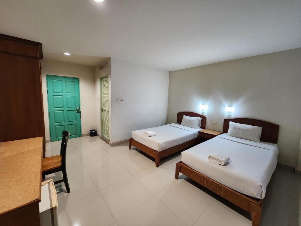 Ban Krabi YaiBaanmai Residence的一间设有两张床和绿门的房间