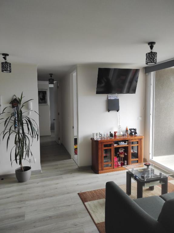 特木科Depto的客厅配有沙发和墙上的电视