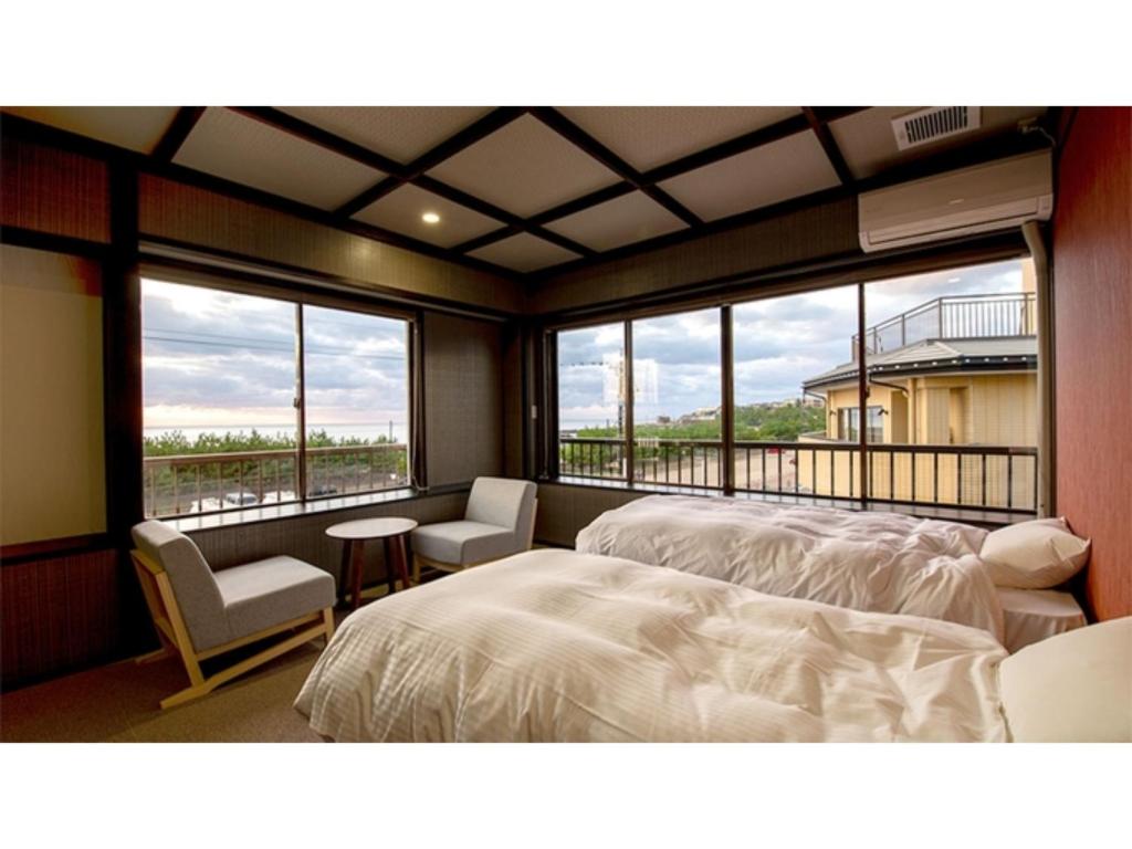 坂井市Taiheian - Vacation STAY 57439v的一间带两张床的卧室和一个窗户阳台