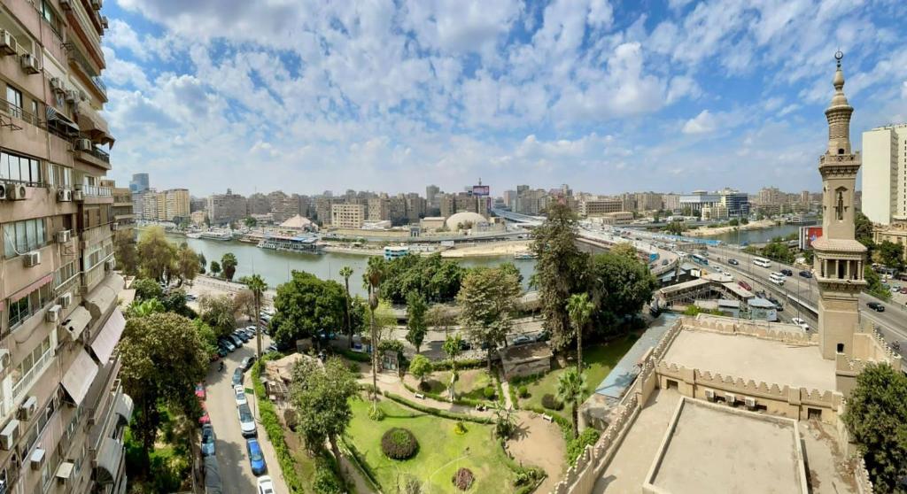 开罗Zamalek X Hostel的享有河流和钟楼城市美景