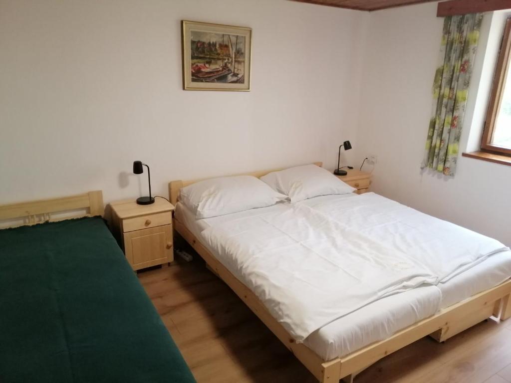 多克西Chata U Selské rokle的卧室配有白色的床和2个床头柜