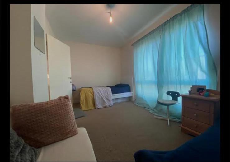 ThamesmeadSelf catered rooms的一间卧室配有一张床、一个梳妆台和一扇窗户。