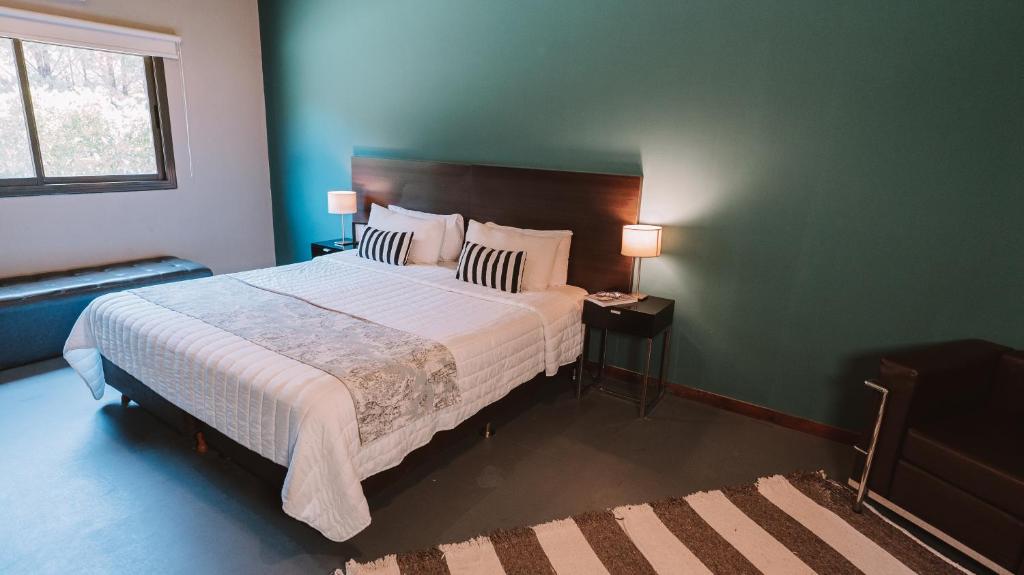 皮拉尔Casa Campus Pilar Suites的一间卧室设有一张大床和绿色的墙壁