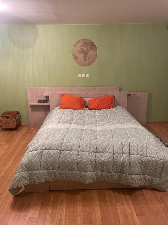PusignanChambre verte spacieuse côté aéroport的一间卧室配有一张大床和两个橙色枕头