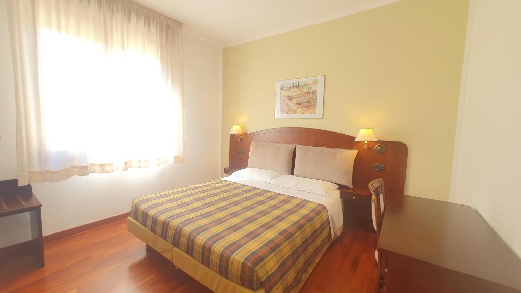Predappio AltaAgriturismo Gli Ulivi的一间卧室配有一张床、一张书桌和一个窗户。