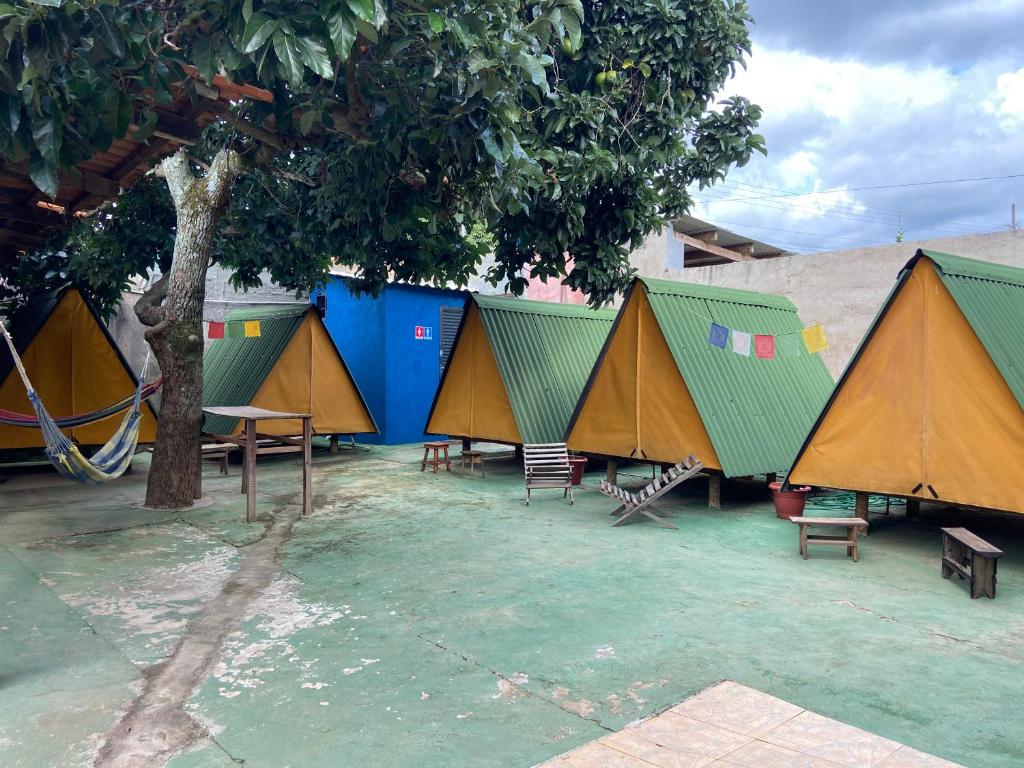 戈亚斯州上帕莱索Ashram no Paraíso.的一组帐篷,配有椅子和一棵树