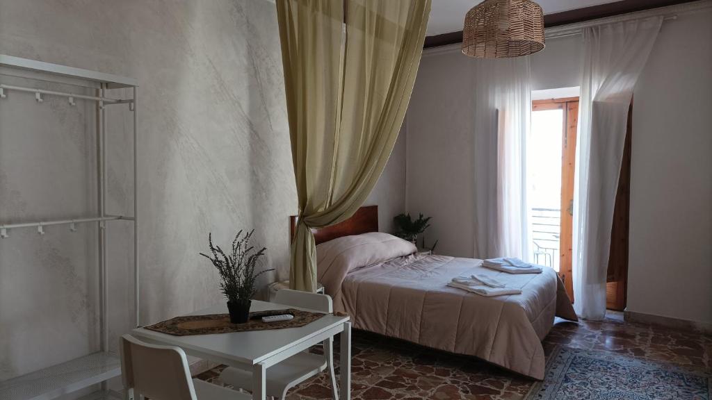 GrottePalazzo montagna的一间卧室配有一张床、一张桌子和一个窗户。