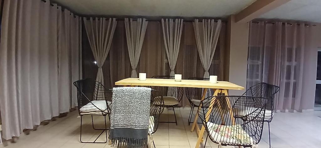 哈博罗内Bakaya Hotel Tlokweng的窗帘间里的桌椅