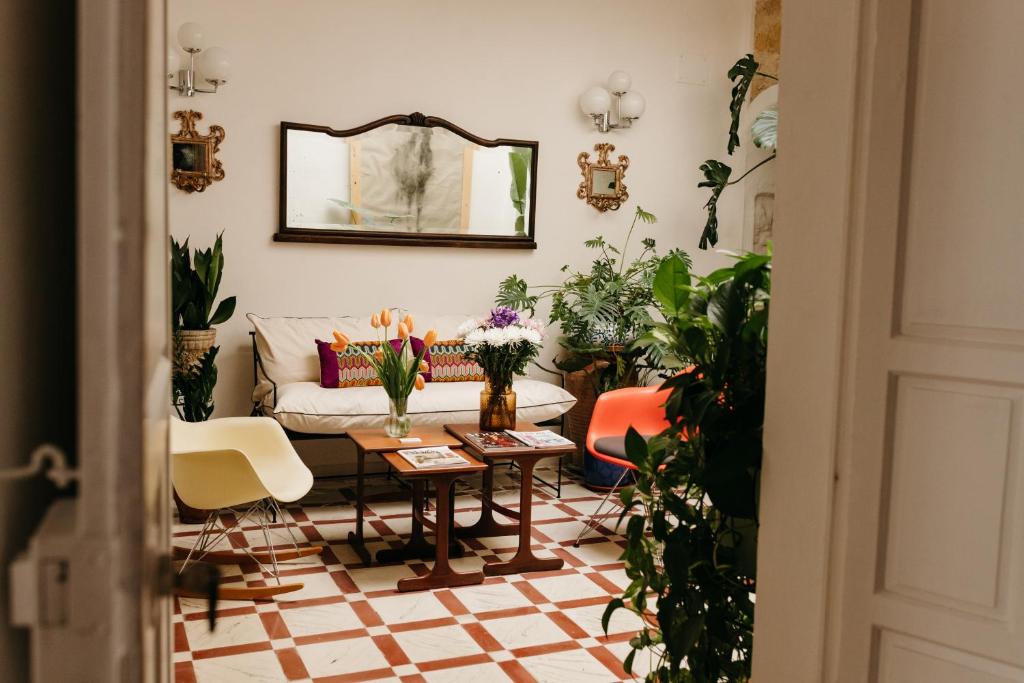 阿尔科斯-德拉弗龙特拉Botánico Casa Rural的带沙发和一些植物的客厅