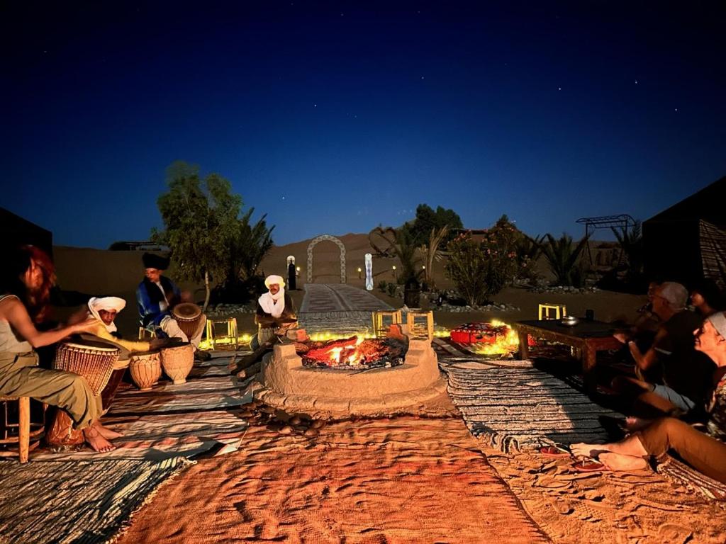 梅尔祖卡Sahara wellness camp的一群人坐在火坑周围