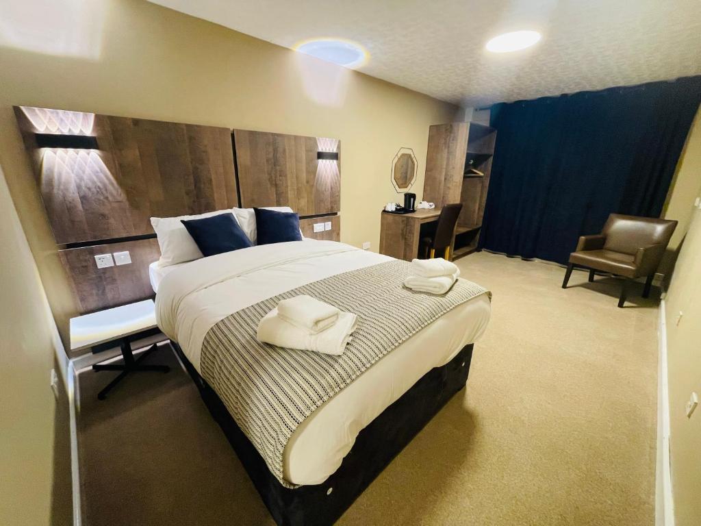 考文垂海兰斯酒店的一间卧室配有一张大床和毛巾