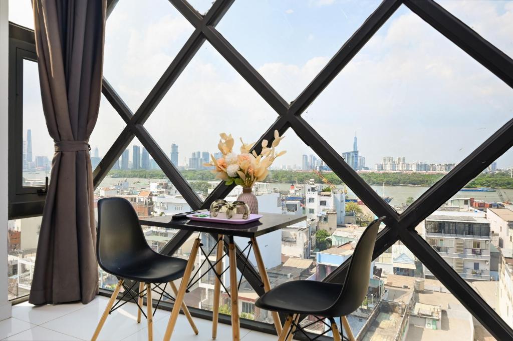 胡志明市Huyen Apartment的客房设有桌椅和大窗户。