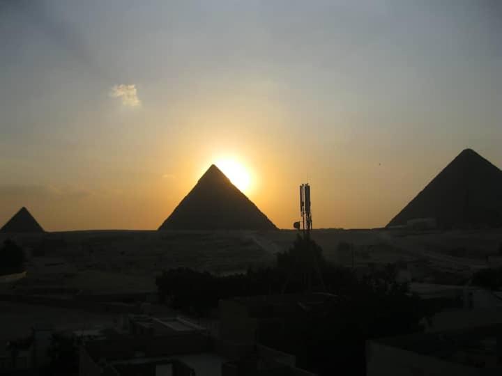 Al Mahallah Al Kubrasunwing pyramids view的沙漠金字塔上的日落