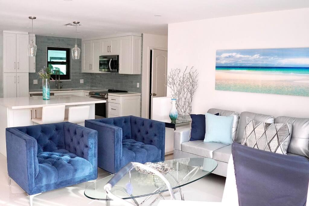 达尼亚滩Stylish home的厨房配有2把蓝色椅子和玻璃桌