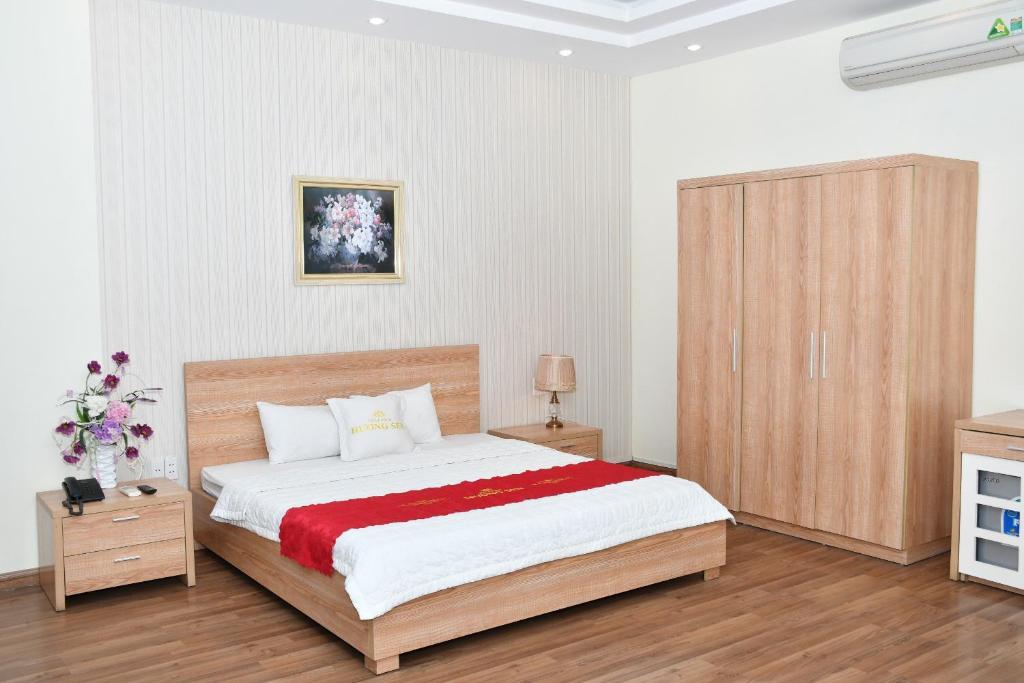 海防Nhà Khách Hương Sen的一间卧室配有一张大床和一个木制橱柜