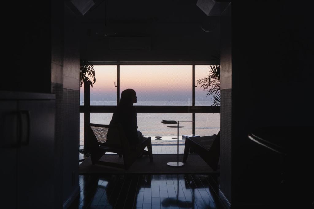 Yamada1999/hotel的坐在椅子上,望着窗外的海洋