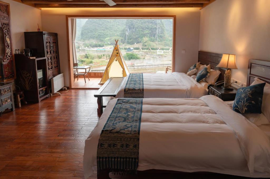 阳朔阳朔水云阁酒店的一间卧室设有两张床和大窗户