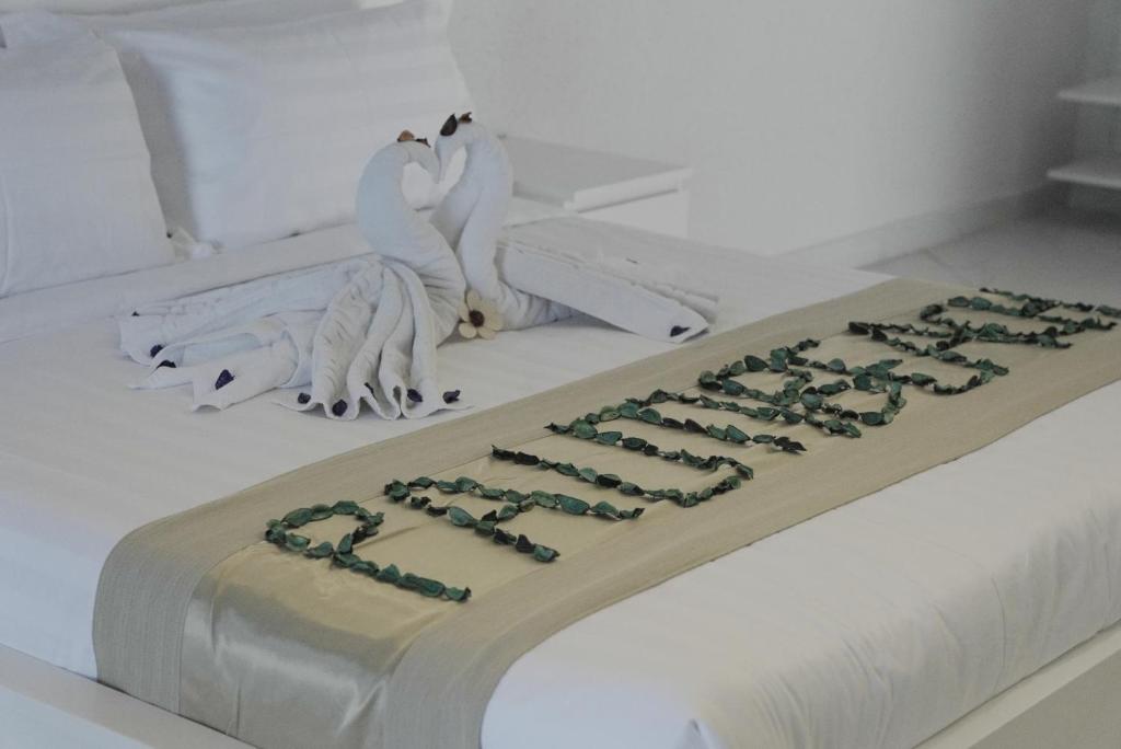 半月湾Palm Beach Resort的床上有两只白鸟的蛋糕