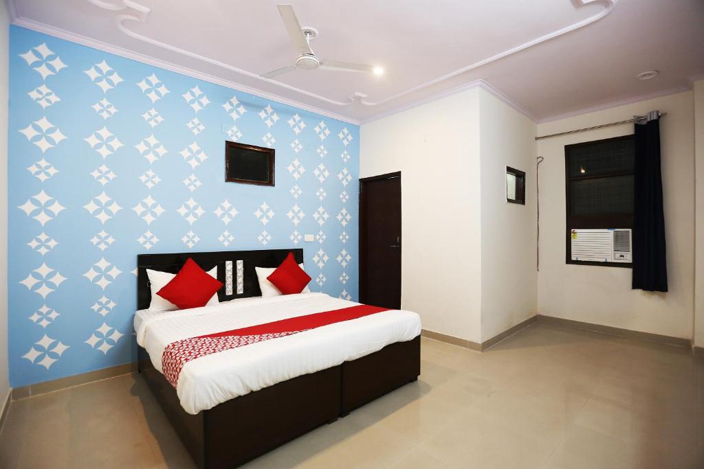 Garhi HarsāruOYO Flagship 44151 Royal Guest House的一间卧室配有红色和白色枕头的床