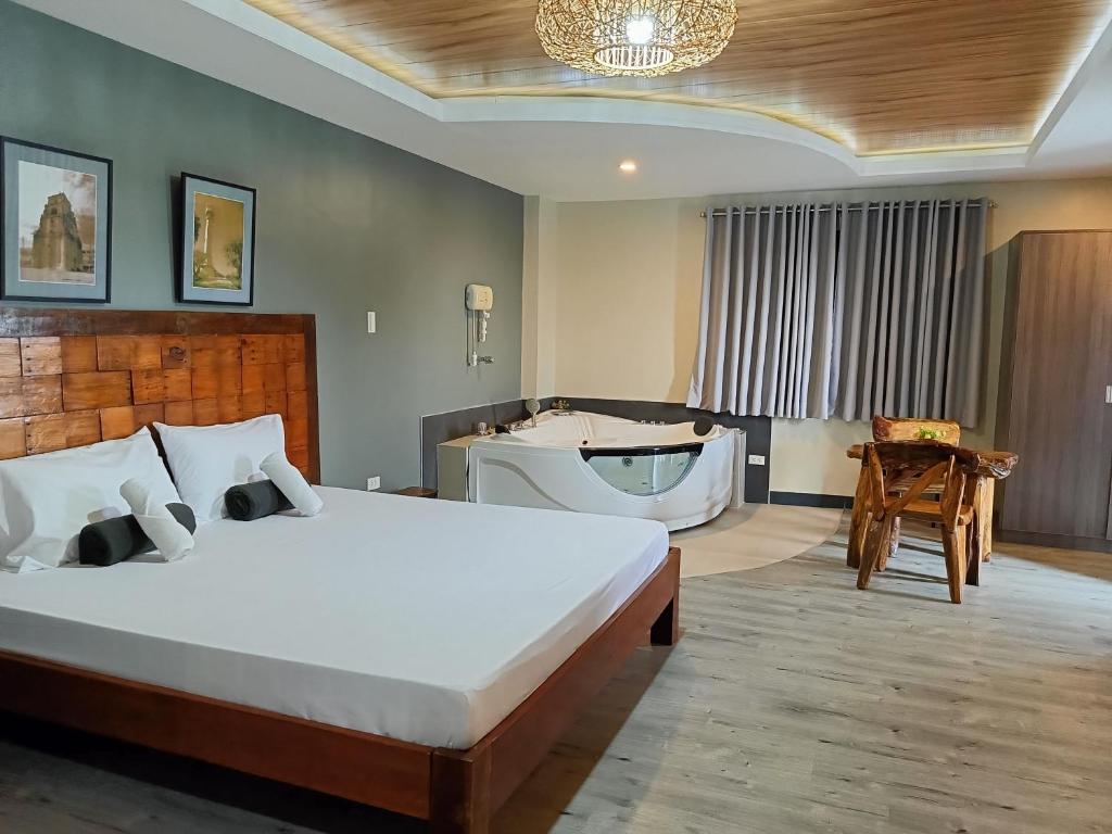 RosarioNorlu Cedec Midpoint Hotel的一间卧室设有一张大床和一个浴缸