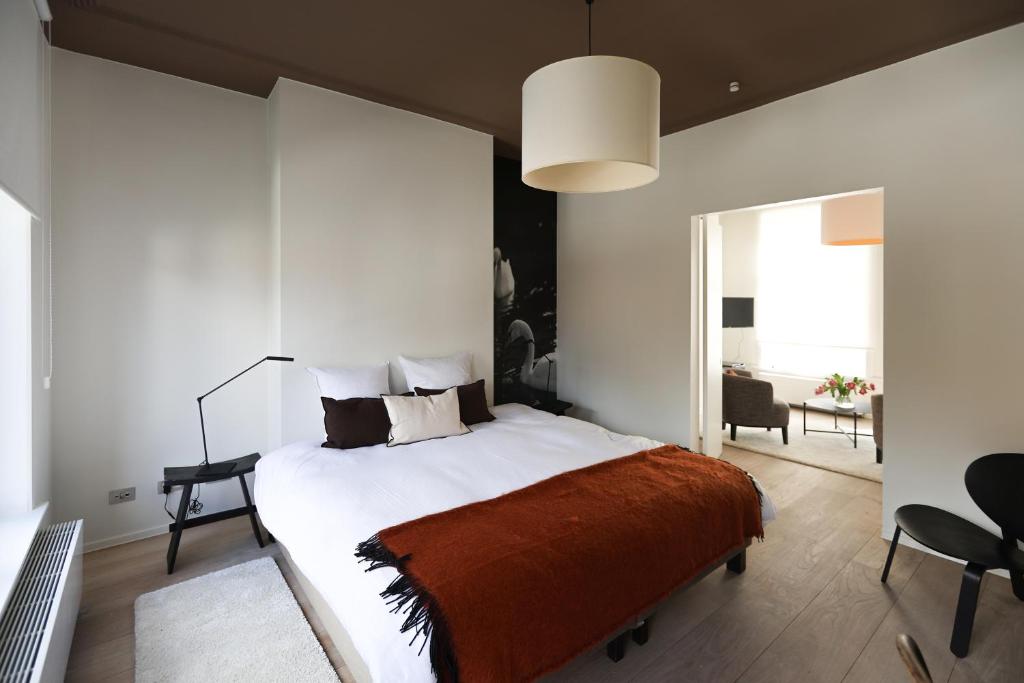 布鲁日Residence9Bruges的一间卧室配有一张带橙色毯子的大床