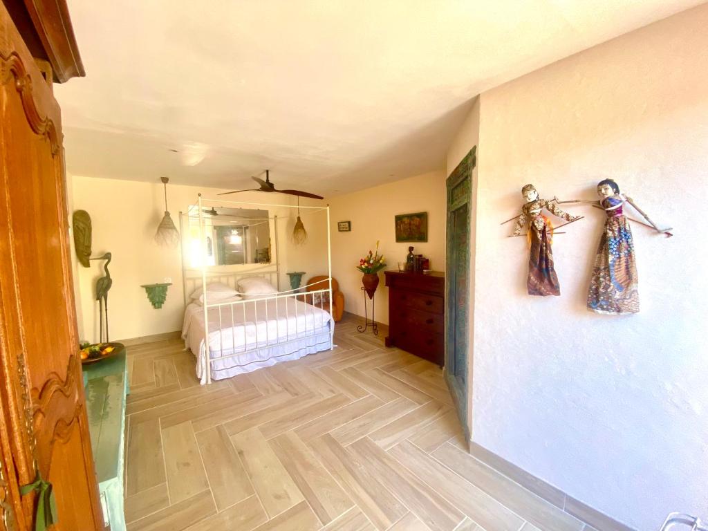 博尔马斯·莱斯·米默萨斯Les Terrasses de Lô的客房设有带一张床的卧室,铺有木地板。