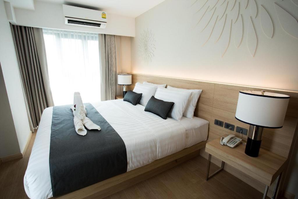 曼谷Iconic Hotel的配有一张大床和一部电话的酒店客房