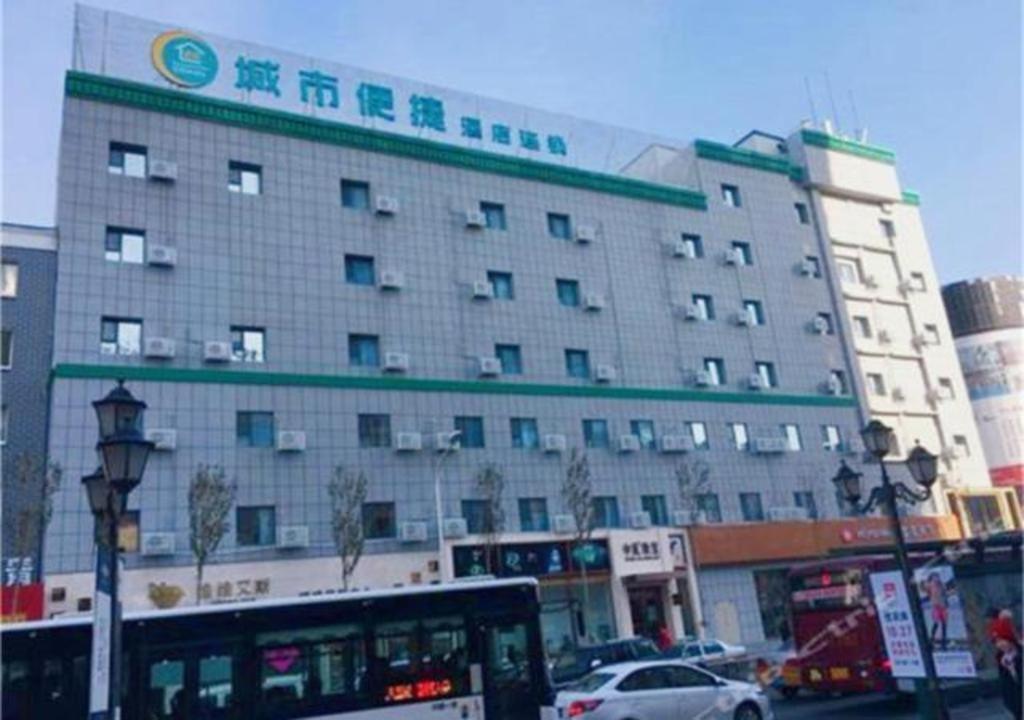 长春City Comfort Inn Changchun Chongqing Road Huolicheng的一座大型建筑,前面有一辆公共汽车