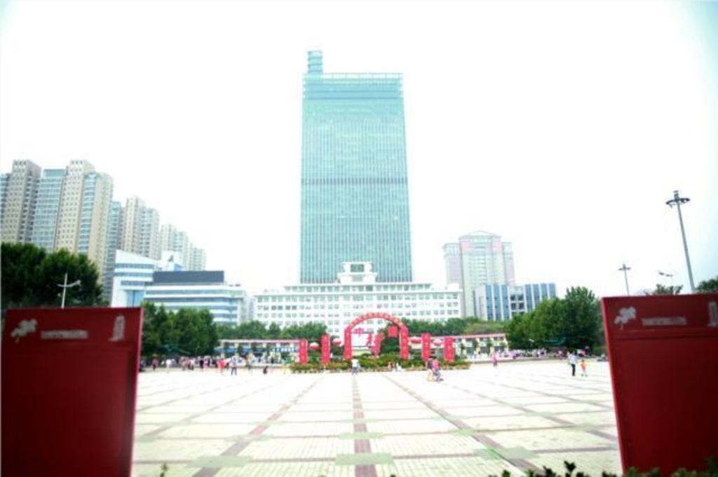 郑州City Comfort Inn Zhengzhou Lvcheng Square Metro Station的一座高楼城市的大广场