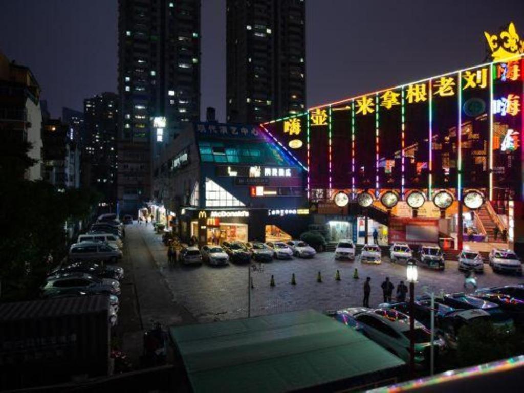 深圳ZMAX Hotels Shenzhen Lianhuacun Metro Station的夜间停车的城市