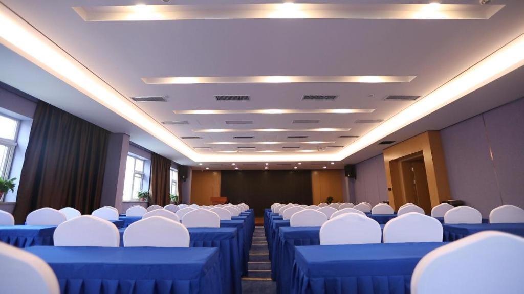 郑州Starway Hotel Zhengzhou Jingguang Road Metro Station的一间会议室,配有蓝色的桌子和白色的椅子