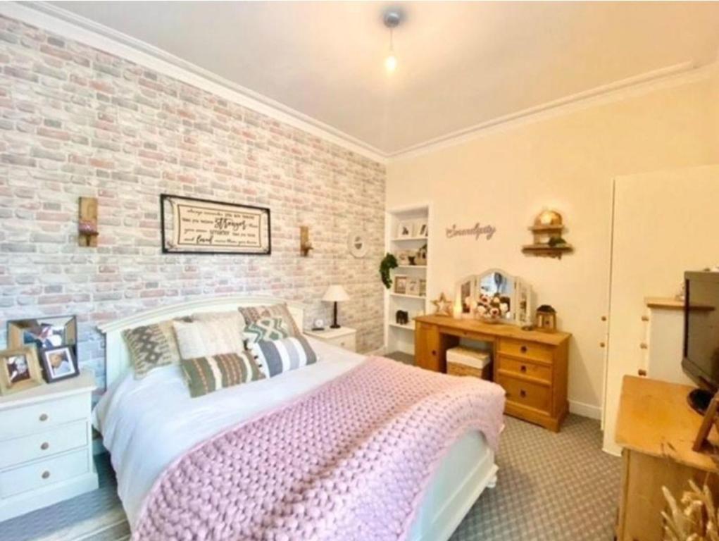 NewmilnsEntire, main door, pet friendly, home away from home, East Ayrshire的一间卧室设有一张床和砖墙