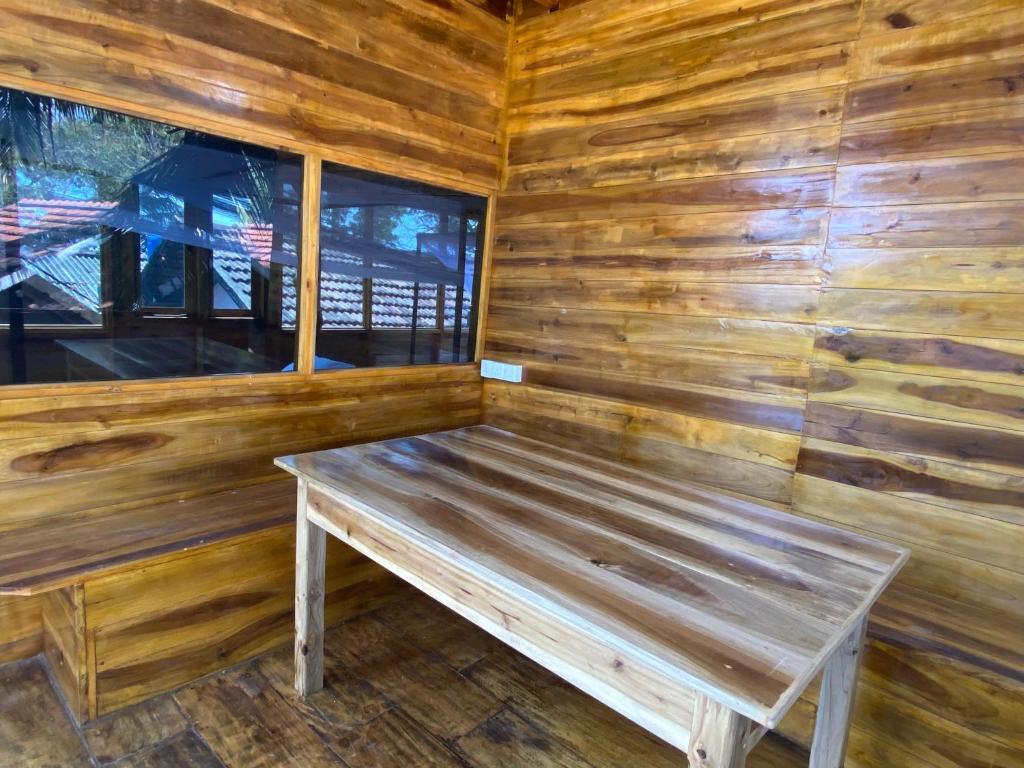 阿鲁甘湾Surf Beach Hotel的木凳坐在小屋内
