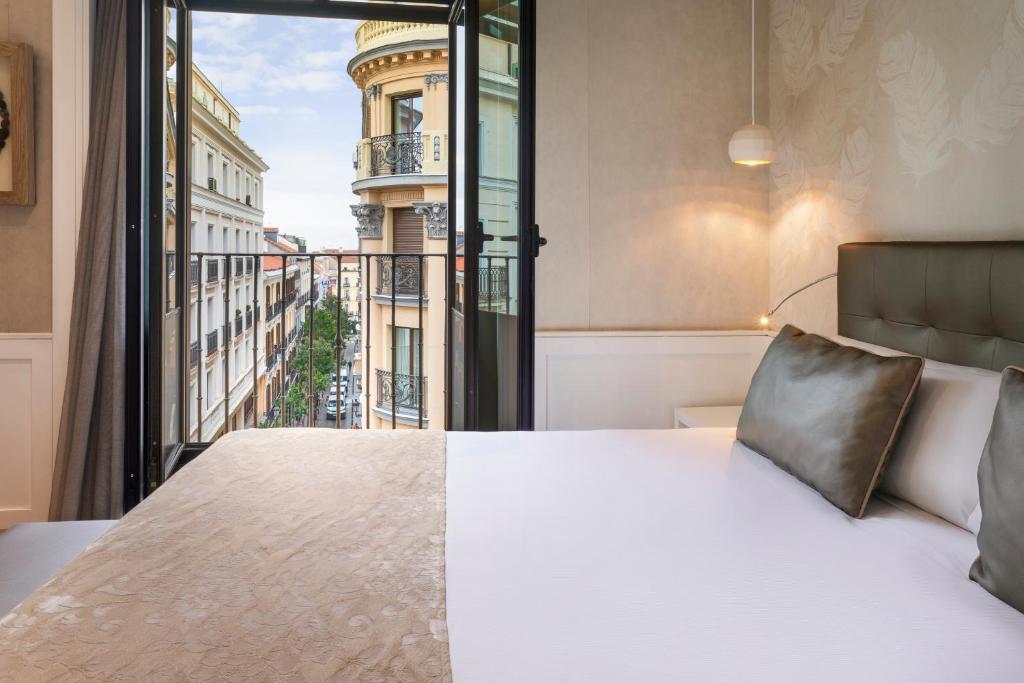 马德里加泰罗尼亚太阳门酒店的一间卧室设有一张床和一个大窗户