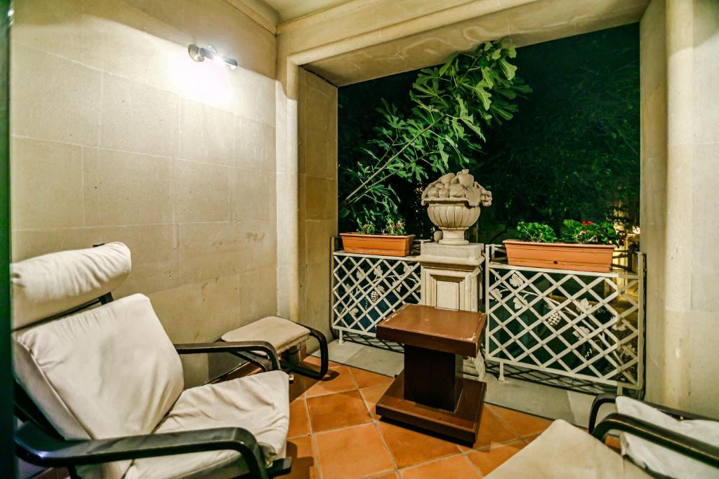 巴库Deniz İnn Hotel的一间设有两把椅子、一张桌子和一个花瓶的房间