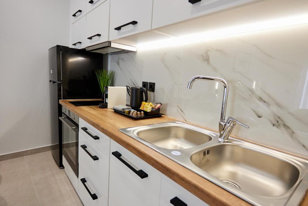 希俄斯Vasilicari Apartments的厨房配有水槽和黑冰箱。